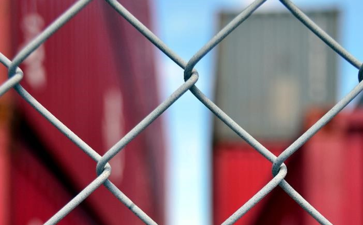 artistic-photo-of-shipping-yard-through-fence