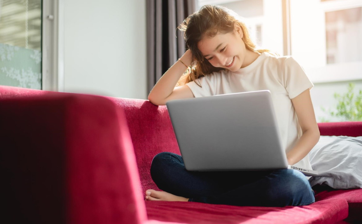 young-woman-with-laptop-on-red-sofa