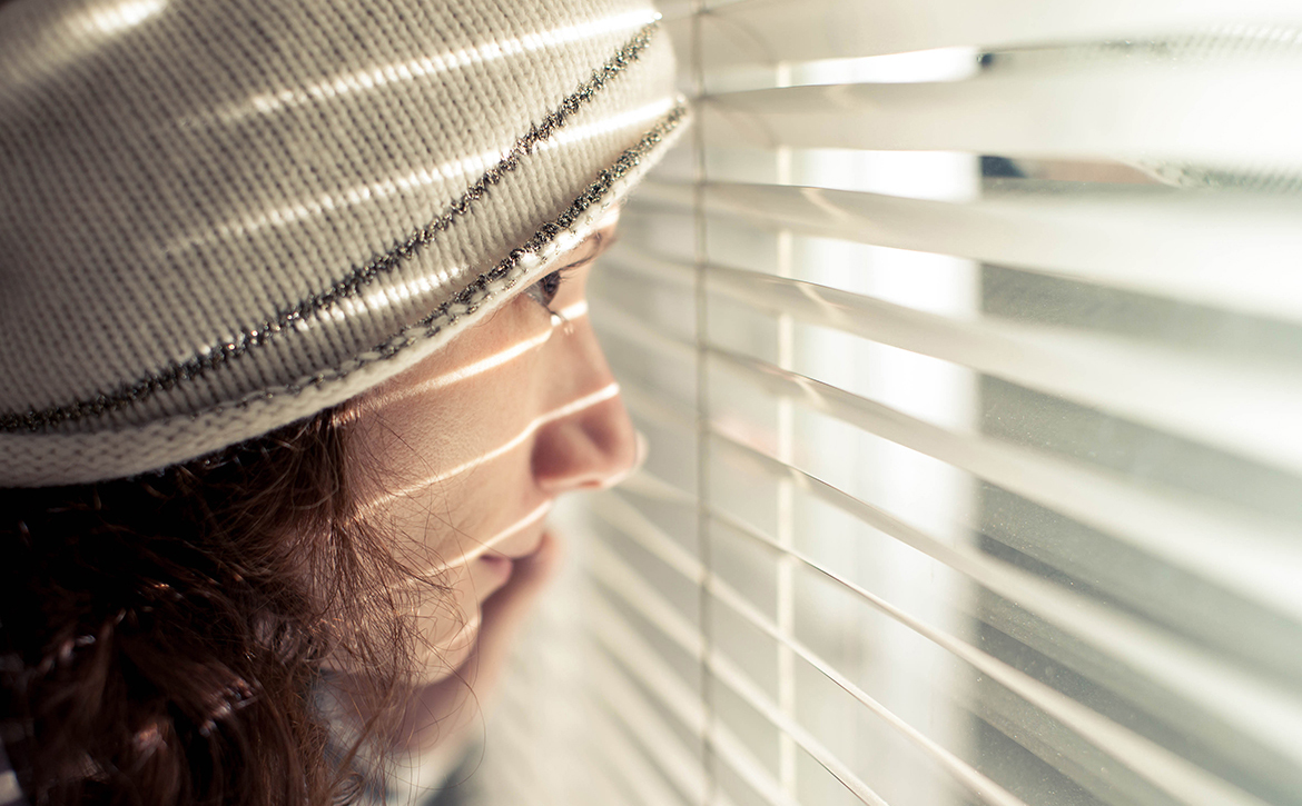 Girl-looking-through-blinds